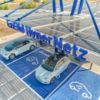 Zwei E-Autos, die gerade laden. Über ihnen steht ein Schild: EnBW Hyper Netz.
