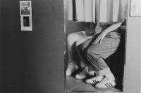 Paar, deren Oberkörper durch Vorhang verdeckt ist, sitzt in Fotobox